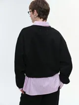 Buzo oversize de corte amplio y relajado, color rojo, con cuello redondo acanalado, mangas anchas y bajo regulable mediante elásticos.