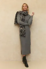 Vestido largo de punto elastizado color gris, de cuello alto y con pequeñas aberturas laterales.