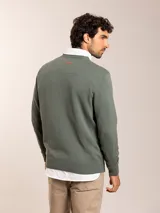 Sweater azul de tejido de punto con cuello redondo y logo bordado en el pecho.