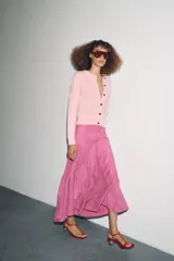 Chaqueta de tejido de punto color verde musgo, de corte cropped, con cuello redondo y cierre frontal de botones oscuros.