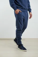 Pantalón jogging de tejido circular con cintura elástica y cordón ajustable. Presenta puños elastizados en los tobillos y bolsillos laterales.