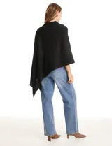 Poncho tejido de punto con diseño asimétrico y aberturas laterales para los brazos.