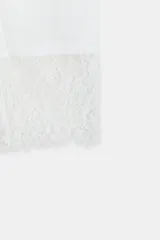Top de manga larga color blanco, confeccionado en algodón, con cuello redondo y detalle de puños combinados en encaje.