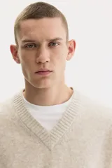 Buzo de punto suave con cuello en V, diseño de corte estándar, mangas largas y terminaciones acanaladas en puños y ruedo.