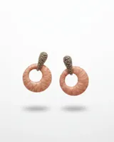 Caravanas colgantes con diseño circular en tono rosado con textura tipo piel, unidas a un cabezal en forma de gota con incrustaciones de brillantes.