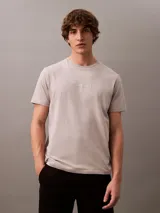 Remera gris claro de algodón con cuello redondo y manga corta. Presenta un estampado tonal con el logo de Calvin Klein Jeans en el pecho.