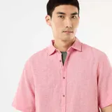 Camisa de manga corta confeccionada en mezcla de lino, de color rosado, con cuello camisero y cierre frontal con botones.