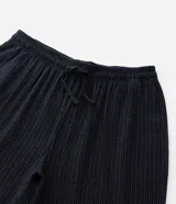 Pantalón de pijama de corte holgado, confeccionado en franela de algodón. Presenta cintura elástica con cordón de ajuste y diseño de rayas verticales.