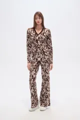 Pantalón de tejido de punto con tiro alto y calce ancho, presentando un estampado pixelado o camuflado en tonos marrón, beige y blanco.