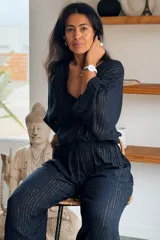 Conjunto de camisa y pantalón de viscosa negro con finas líneas metalizadas doradas. La camisa es de manga larga con escote en V y botones frontales, mientras que el pantalón es de corte ancho y tiro alto con cintura elástica fruncida.
