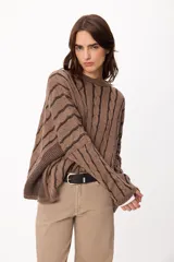 Sweater de tejido de punto con diseño de rayas verticales y textura de ochos, en color marrón. Presenta cuello redondo, corte holgado y mangas largas.