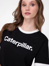 Remera corta tipo ringer de color negro, con ribetes blancos en el cuello y los puños de las mangas cortas. Presenta el logo de Caterpillar estampado en blanco en el centro del pecho.