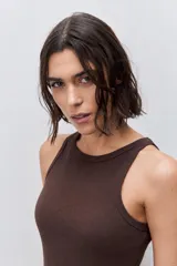 Musculosa de calce ajustado color rojo, confeccionada en algodón con elastano. Presenta escote redondo alto y textura acanalada.