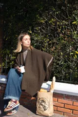 Ruana marrón de tejido de punto grueso, confeccionada en 100% baby alpaca.