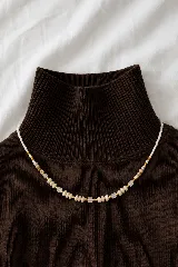 Collar de diseño artesanal compuesto por una combinación de cuentas de perlas pequeñas, cuentas cilíndricas doradas, cuentas de piedra natural y cuentas cuadradas de vidrio esmerilado.