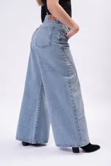 Pantalón de denim estilo wide leg, de tiro bajo, color celeste, con costuras frontales destacadas y corte muy ancho.