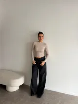Pantalón de jean negro de tiro alto y corte wide leg, con diseño amplio y dobladillo ancho vuelto hacia arriba.