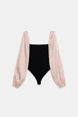 Body de escote cuadrado con cuerpo en tejido elástico negro y mangas largas abullonadas en tejido satinado color rosado con puños elásticos.