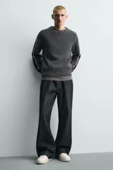 Zapatilla deportiva de estilo retro con diseño de paneles en combinación de colores crema, verde azulado y detalle en rojo en el talón. Presenta suela con volumen y cierre con cordones.