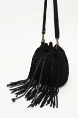 Cartera tipo bucket bag de cuero vacuno negro, con diseño de flecos largos decorados con tachas metálicas pequeñas. Cuenta con cierre de cordón ajustable, correa larga para el hombro y herrajes metálicos en tono bronce.