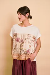 Blusa de manga corta color blanco con diseño floral y de aves estampado en la parte frontal y trasera.