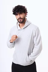 Buzo con capucha y bolsillo frontal tipo canguro, confeccionado en tela de felpa, con cordones ajustables en el cuello y puños elásticos.