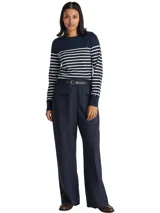 Sweater de Tommy Hilfiger con diseño de rayas horizontales en azul marino y blanco. Presenta cuello redondo, manga larga y detalle de botones decorativos dorados en uno de los hombros.