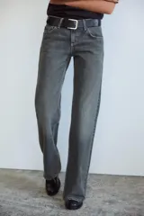 Jeans de mezclilla azul oscuro con efecto lavado, tiro bajo y pierna ancha extra larga. Modelo de cinco bolsillos con cierre frontal de cremallera y botón metálico.