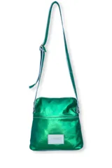 Cartera tipo bandolera de cuero natural con acabado metalizado en color verde. Presenta un diseño cuadrado con costuras visibles, correa larga ajustable y un parche rectangular con el logo de la marca en la parte frontal.