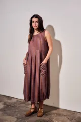 Vestido midi sin mangas, con diseño a rayas en tonos marrón y azul, cuello redondo y bolsillos laterales amplios.