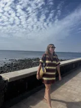 Vestido corto de tejido de punto con cuello polo y escote en V, manga corta y diseño a rayas horizontales anchas en tonos marrón chocolate y amarillo claro.