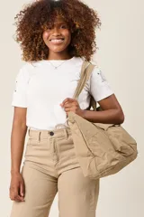 Bolso tote color beige, de tela tipo paracaídas, con doble asa de mano y bolsillo frontal con solapa.