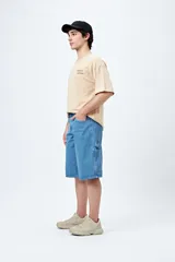 Bermuda de denim negro, estilo carpenter, con corte relajado y largo por encima de la rodilla. Presenta costuras visibles y múltiples bolsillos funcionales.