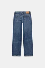 Jeans de mezclilla en color negro gastado, tiro bajo, corte de pernera recta y diseño clásico de cinco bolsillos con cierre frontal de cremallera y botón metálico.