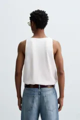 Camiseta sin mangas (tank top) blanca de algodón, con cuello redondo amplio y corte relajado (relaxed fit).