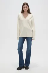 Sweater de punto color natural con diseño de ochos, cuello en V y calce holgado.