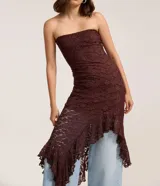 Vestido midi strapless de encaje floral bordó, con corte ajustado hasta la cadera y bajo asimétrico decorado con volados.