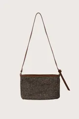 Bolso satchel rectangular de paja tejida en tonos negro y beige, con ribetes y correa de cuero marrón. La correa es larga y delgada, y se ata a los lados del bolso con nudos.