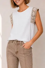 Blusa de lino color beige sin mangas, con cuello redondo y detalles de crochet en los hombros.