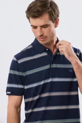 Remera polo de manga corta con diseño a rayas horizontales en tonos azules, celestes, verdes y beiges sobre base azul marino. Presenta cuello camisero con cierre frontal de botones y un pequeño logo bordado en el pecho.