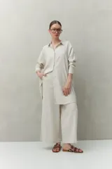 Vestido camisero de lino color beige, con botones tipo mostacillas, corte recto y largo midi.