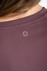 Remera de fitness color bordó, de corte holgado, cuello redondo y mangas cortas. Confeccionada en tejido técnico de secado rápido.