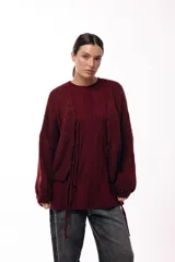 Sweater de punto con textura en color bordó, de silueta relajada, cuello redondo y mangas largas con puños ajustados.