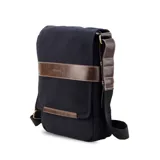 Morral de tela canvas color negro con detalles en cuero sintético marrón. Cuenta con solapa frontal con cierre magnético, bolsillo tipo guantera bajo la solapa, división interna desmontable con velcro y correa larga regulable.