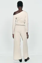 Pantalón de tiro alto y pierna recta, confeccionado en tejido piqué color beige. Presenta cintura elástica y un cinturón fino a contraste en color negro con detalle de pieza metálica central.