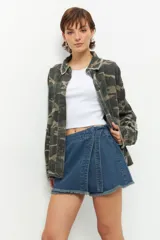 Short pollera de jean prelavado con lazo en uno de sus laterales y detalle de flecos en las terminaciones.