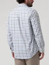 Camisa de franela de algodón orgánico para hombre, con diseño de cuadros en tonos celestes, azules y oscuros sobre base blanca. Presenta cuello abotonado, cierre frontal de botones, bolsillo aplicado en el pecho y un pequeño bordado distintivo de la marca RKF.