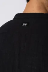 Camisa de manga larga confeccionada en lino, con cuello clásico y cierre frontal de botones. Presenta un diseño de calce suelto y textura suave, ideal para un estilo relajado.