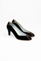 Zapatos de tacón de línea clásica confeccionados en terciopelo negro con aplicaciones de plata. Presentan un diseño estructurado con puntera, laterales y talonera divididos por ribetes en piel tornasolada, con interior en piel y suela de cuero.