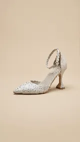 Zapato de tacón con punta fina, confeccionado en tela con strass aplicados en la capellada y detalles en cuero en el talón, taco y pulsera. Presenta un taco de diseño acampanado y cierre con hebilla en el tobillo.